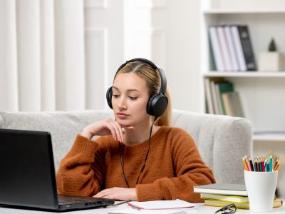 student-online-cute-girl-glasses-sweater-studying-computer-thinking-listening